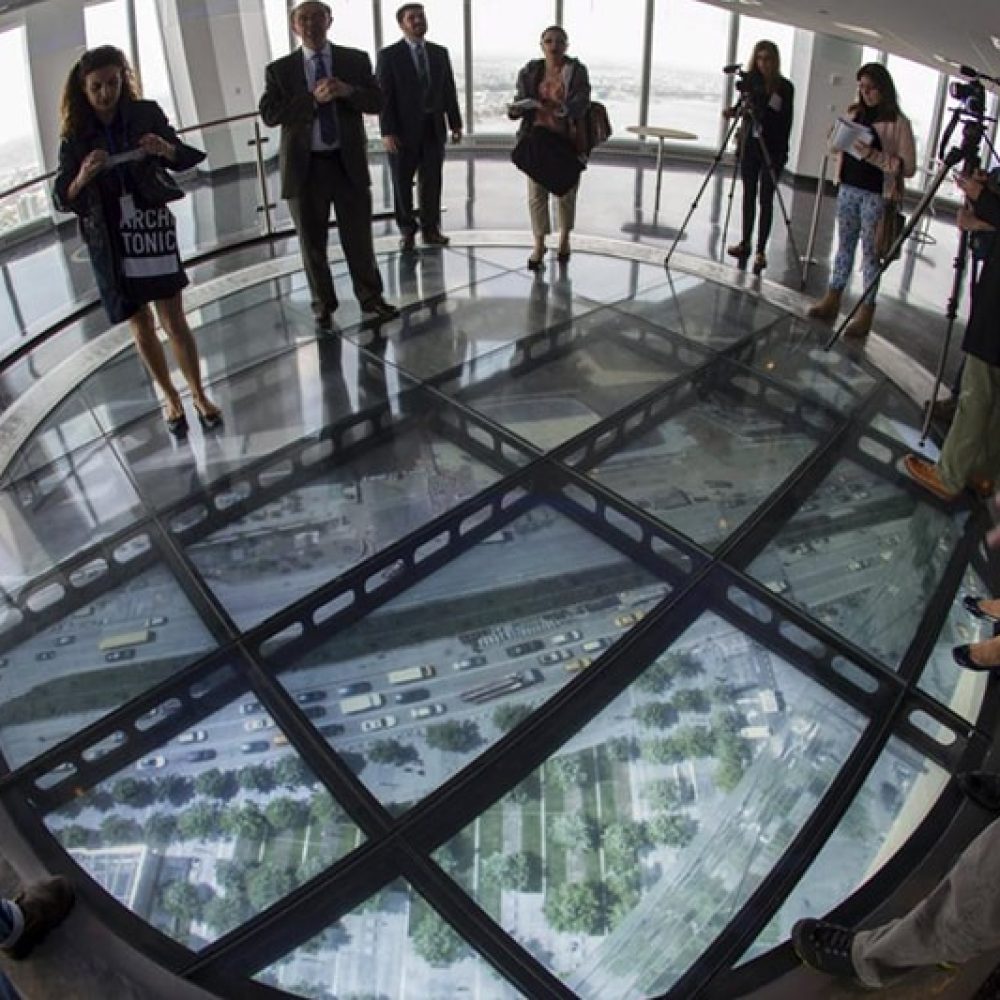 Media stand on the SkyPortal, a 14-foot wide disc that delivers high-definition live video footage from the street below, in the One World Observatory observation deck on the 100th floor of the One World Trade center tower in New York during a media tour of the site May 20, 2015. One World Observatory will open to the public on May 29.  REUTERS/Mike Segar